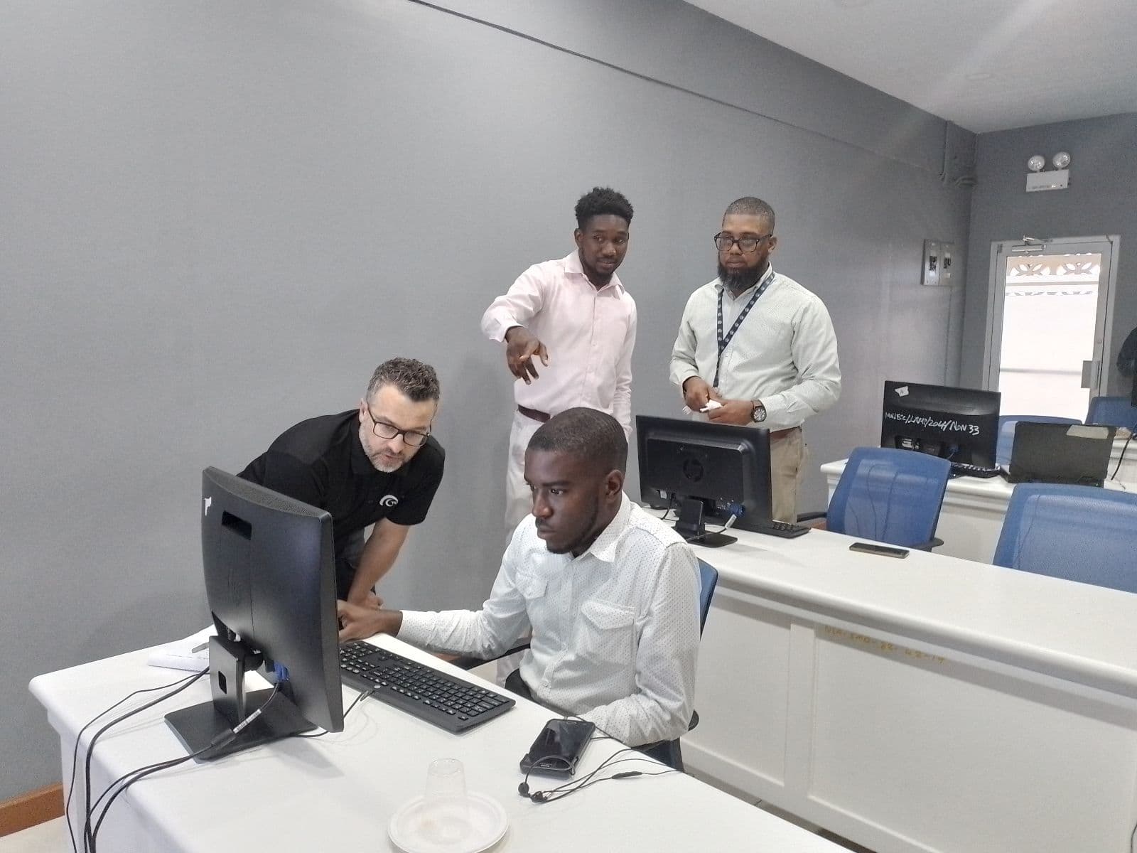 TCarta instructor providing hands-on SDB integration training to participants at a computer workstation during a capacity building workshop in Jamaica